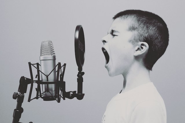 Enfant criant à pleine voix dans un micro de studio