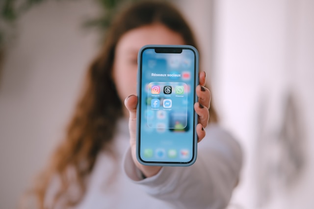 A person at a desk looking at their phone with a WhatsApp voice-message notification