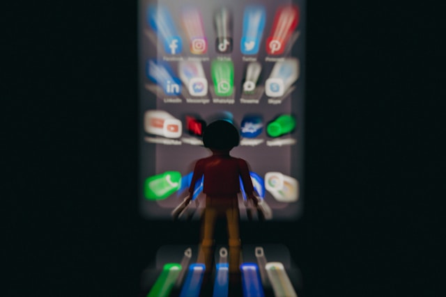 A manager recording a voice note on their phone while an employee looks at the screen wearily